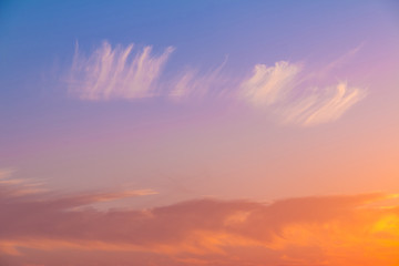 Beautiful cloudscape at scarlet sunset with colorful contrasting cirrus clouds
