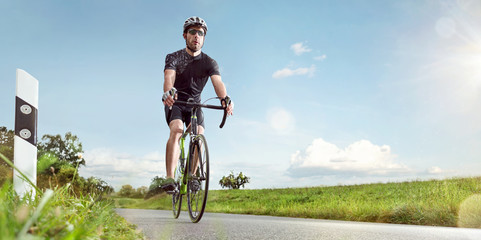 Fototapeta na wymiar Sportlicher Radfahrer auf einer sonnigen Landstraße
