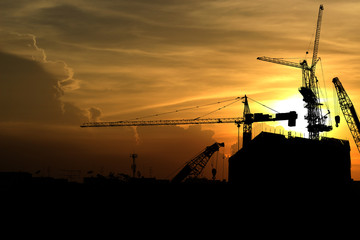 Silhouette crane construction building at sunset