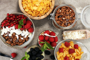 Cereal and ingredients for a healthy breakfast with chia pudding, granola, cornflakes and berries