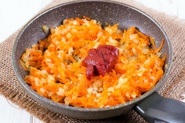 Tomato onion carrot and tomato paste in a pan