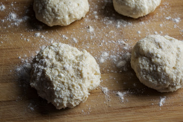 round dough with flour on a wooden board