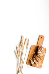 Homemade fresh bread sliced on cutting board on white background top view copy space