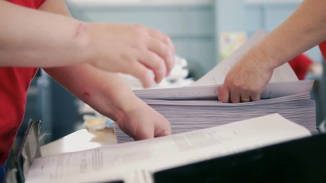 Hands of female workers laid the printed edition
