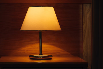 Vintage lamp on night table in hotel room