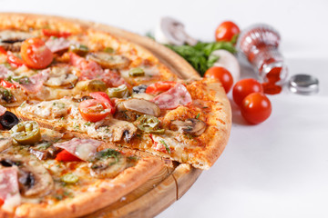 Italian kitchen and cooking concept. Hot tasty sliced with ham, sausage, jalapenos, mushrooms, tomato. Eat delivery concept.