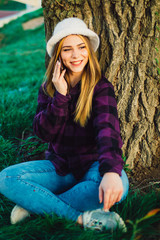Blonde girl near a tree talking on the phone