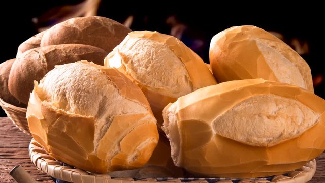 Basket of "French bread", traditional Brazilian bread and butter with fire background
