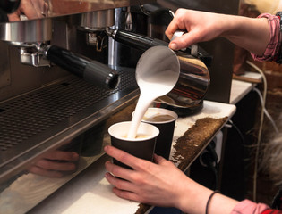 Fototapeta na wymiar Barista making fresh takeaway coffee. Close-up view on hands with portafilter, barista coffee preparation service concept. 