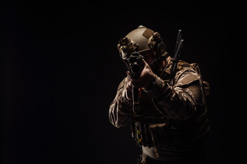 Fototapeta na wymiar Special forces United States soldier or private military contractor holding rifle. Image on a black background.