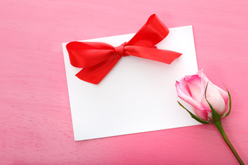 Rose with greeting card on a pink background