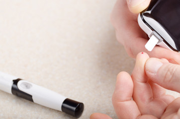 Fototapeta premium Man doing blood test with personal glucometer