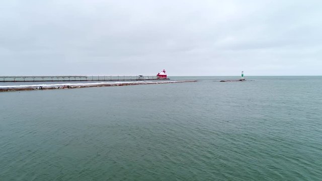 Time lapse aerial flyby of remote lighthouse coated with ice and snow.
