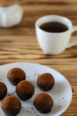 Chocolate candy on a wooden table with a cup of coffee