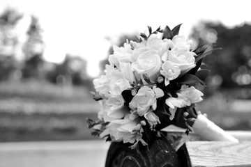 Bouquet of a bride on a white bench. Beautiful wedding bouquet. Black and white.