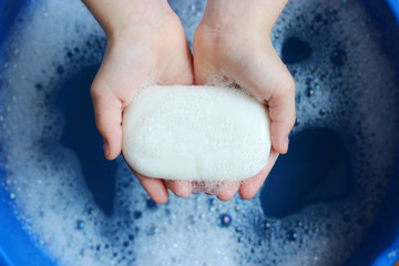 Fototapeta premium soap and soap foam in children's hands on a beautiful blue background. to wash hands. children's hygiene. hand hygiene. 