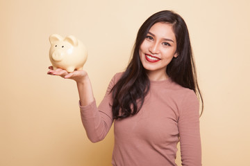 Young Asian woman with a pig coin bank.