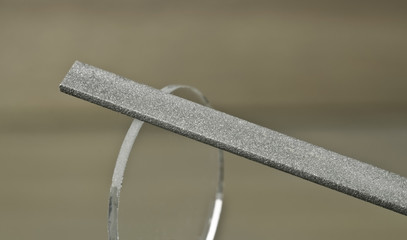 grinding the edges of the glass with a diamond file by hand