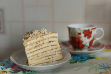 cup of tea with piece of cake on table.