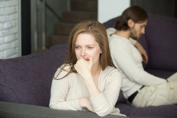 Sad disappointed wife not talking ignoring husband after fight sitting on sofa, upset frustrated woman feeling offended tired of problems, thinking of divorce or can not forgive betrayal cheating