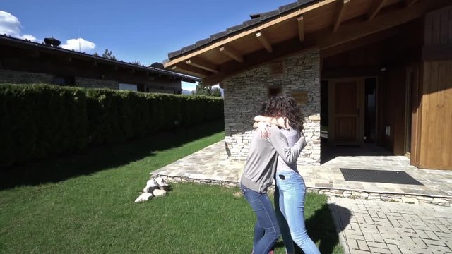 Girl return home from trip and exchange emotions with mother hugging and kissing  SLOW MOTION