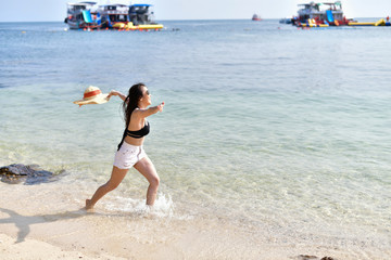 Beautiful woman wearing a swimsuit playing in the beach.
