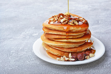 Tasty breakfast. Homemade pancakes with crushed hazelnut, honey or maple syrup