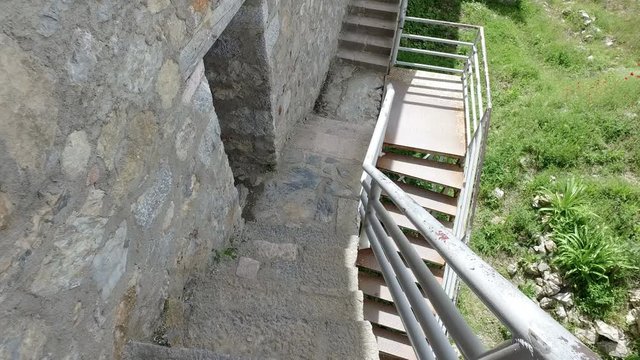 Walking pov down the stairs from watchtower of famous old fortress ruins of tzar Samuel in Ohrid know as Samuels fortress with Lake Ohrid in the background. Ohrid - Macedonia
