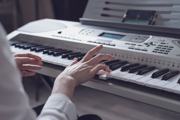 Cropped image of a woman learning to play the synthesizer using the application in the smartphone