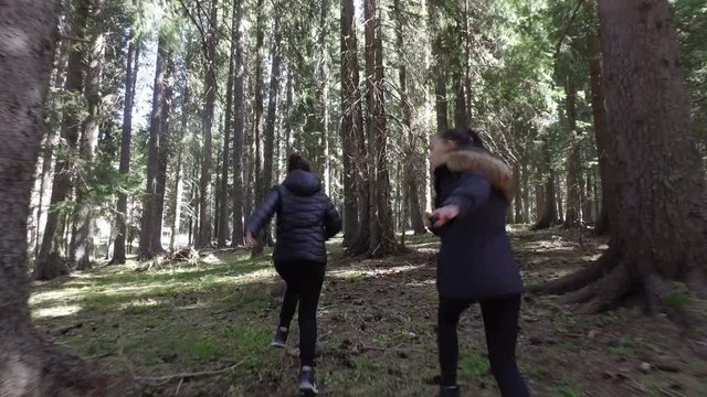 Two girls trying to escape of someone who chases them in the forest