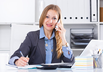 Woman talking on phone in office