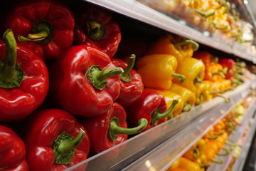 Fresh red, yellow and green giant paprikas on shelf in the supermarket.