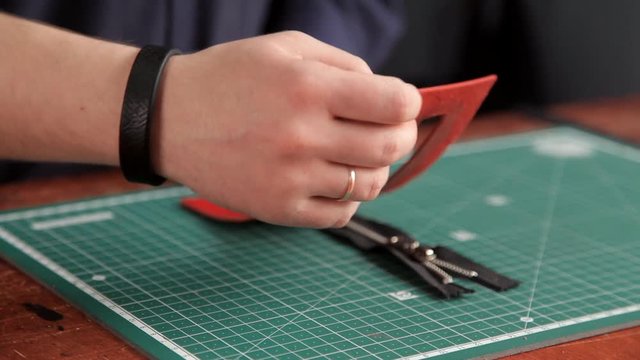 The artisan in the workshop glues the leather blanks, making the leather product