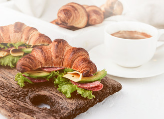 Fototapeta na wymiar breakfast of croissant sandwich coffee and a glass of juice