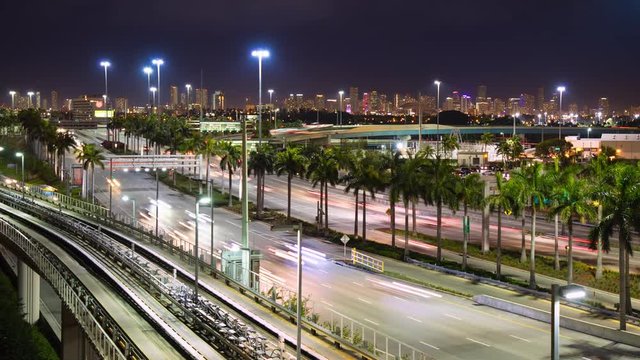 Miami FL Metropolis at Night Timelapse with Streaking Lights from Fast Moving Traffic on Lit Highways and Interstates in front of a Vibrant South Beach Cityscape Background on a Colorful Evening
