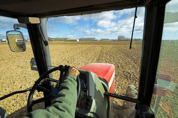 inside the cab of a tractor and view of the field working