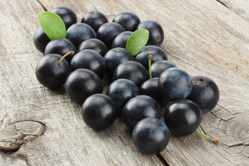 blackthorn berries with green leaf on old wooden table
