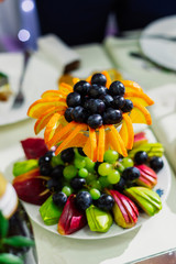 Fruit slicing on a plate, decorated table.