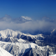 Fototapeta premium Sunlight snowy mountains in fog