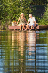 Senior couple at the lake. Woman and man, summer day.