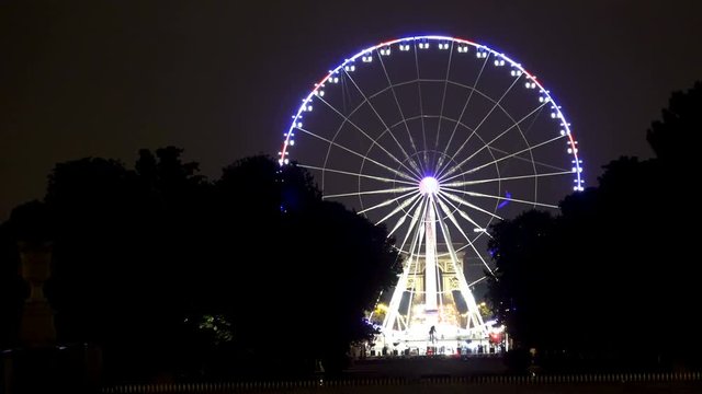 A ferris wheel (Roue de Paris) on the Place de la Concorde at night from the Tuileries Garden in Paris. It was first installed for the 2000 millennium celebrations
