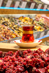 Traditional glass of Turkish tea on the bazaar, against the background of oriental sweets