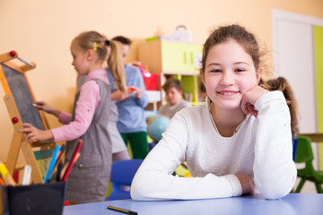 Smiling schoolgirl in classroom during break