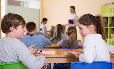 Fototapeta na wymiar Schoolchildren chatting during lesson