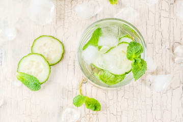 Summer fresh iced drink, mint and cucumber infused water, summer healthy detox mojito cocktail, light background copy space