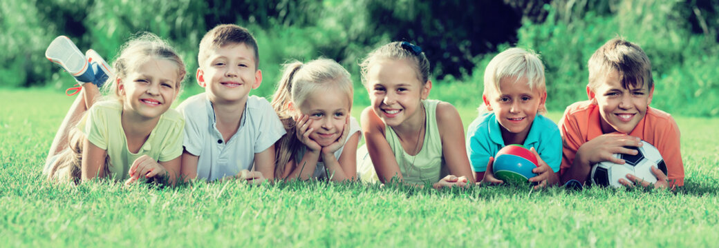 portrait of  children lying on grass in park and looking happy