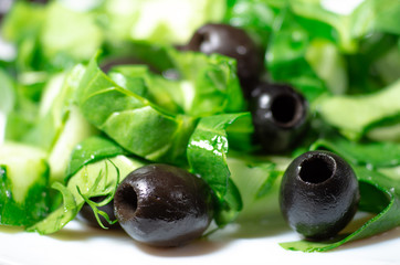 Marinated olives without pits and spinach close-up