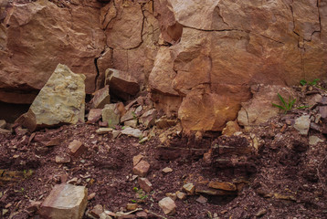 Fototapeta premium Background of natural sandstone, banded, red or brown, colored texture background. Stone surface texture closeup. Deposit, quarry for the extraction of sandstone stone. Mining, natural resources