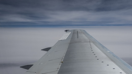 Fototapeta na wymiar wing of airplane above the clouds