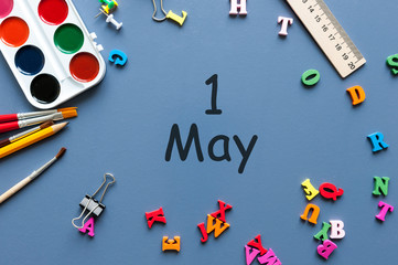 May 1st. Day 1 of may month, calendar on school table, workplace at blue background. Spring time, International Labour day